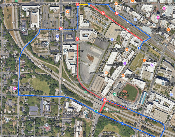 Aerial map of downtown Durham showing red closure segments and blue detour routes.